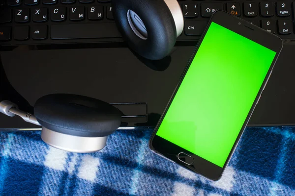 Laptop ve kulaklık smartphone anahtar chroma ekran için yeşil ekran ile. Vintage mavi yatak örtüsü içinde — Stok fotoğraf