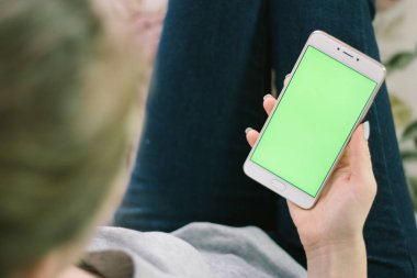 Bir smartphone bir yeşil ekran yeşil ekran, beyaz zemin üzerine, yeni teknoloji kavramı chroma anahtar yeşil ekran ile mobil akıllı telefon tutan adamın elini elinde tutan güzel kız