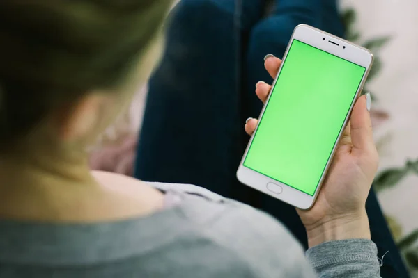 Bir smartphone bir yeşil ekran yeşil ekran, beyaz zemin üzerine, yeni teknoloji kavramı chroma anahtar yeşil ekran ile mobil akıllı telefon tutan adamın elini elinde tutan güzel kız