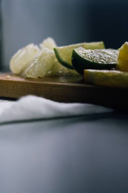 Bir yığın narenciye dilimi. Portakal, limon, greyfurt, pomelo. Tahta masada.