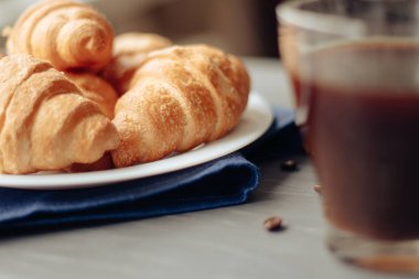 Kahve fincanı ve ahşap arka planda taze pişmiş kruvasan. Üst Görünüm.