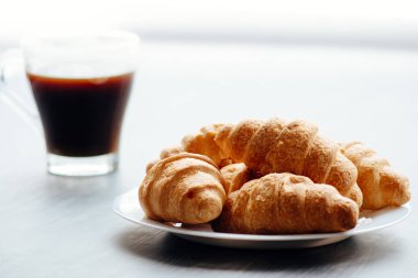 Kahve fincanı ve ahşap arka planda taze pişmiş kruvasan. Üst Görünüm.