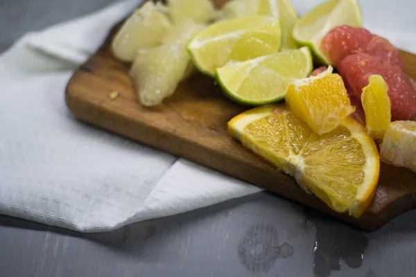 감귤 열매를 쌓아 놓는다. 오렌지, 레몬 라임, 그레이프프루트, 포렐 로. 나무 탁자 위 에서 — 스톡 사진