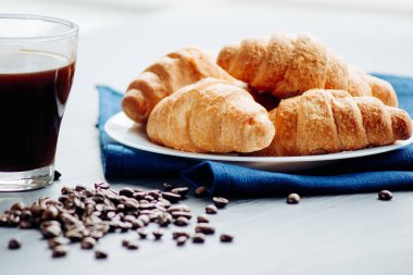 Kahve fincanı ve ahşap arka planda taze pişmiş kruvasan. Üst Görünüm.