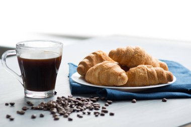 Kahve fincanı ve ahşap arka planda taze pişmiş kruvasan. Üst Görünüm.