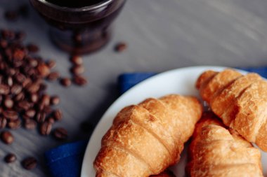 Kahve fincanı ve ahşap arka planda taze pişmiş kruvasan. Üst Görünüm.