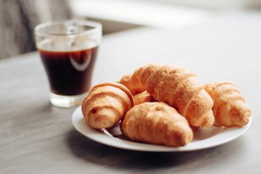 Kahve fincanı ve ahşap arka planda taze pişmiş kruvasan. Üst Görünüm.