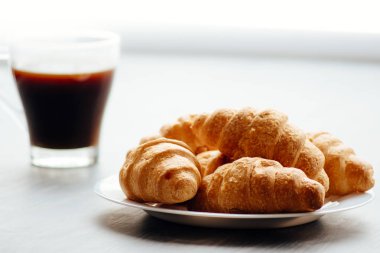 Kahve fincanı ve ahşap arka planda taze pişmiş kruvasan. Üst Görünüm.