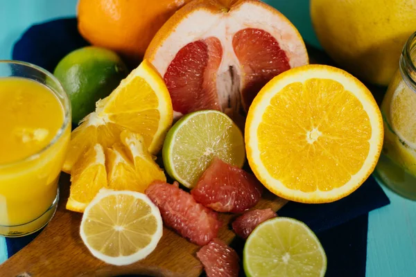 감귤 류, 오렌지, 레몬, 라임, 자 몽, 포 멜로 빈티지 보드, 레모네이드와 청록색 배경에서 유리의 유리에서 주스에 — 스톡 사진