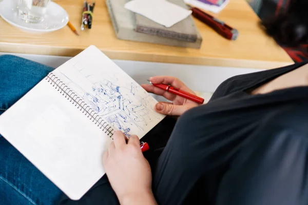 Hübsche lächelnde junge Frau, die ein Bild mit Plakatfarbe zeichnet. Frontansicht auf zeichnendes Mädchen mit Palette in der Hand. Lächelnde junge Frau zeichnet ein Bild im Atelier — Stockfoto