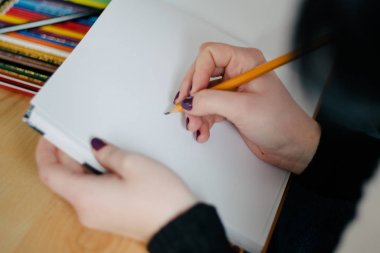 Bir Office kadın Holding kalem ve defter iken yapma bazı notlar dizüstü bilgisayar ile onu masada el kadar kapatın.