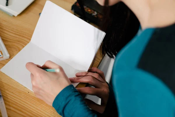 Dans le bloc-notes au bureau Gros plan des mains féminines prenant des notes — Photo