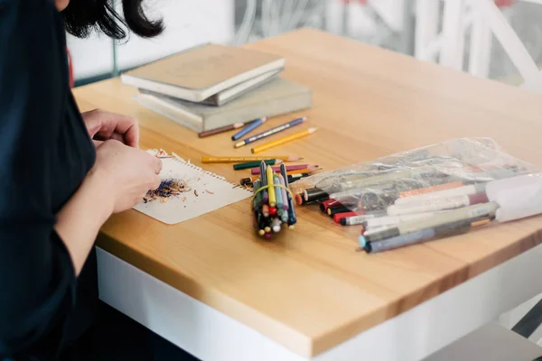 Taille-crayon beaucoup de crayons sur la table Gros plan des mains de la femme en utilisant le vert — Photo