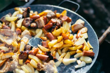 Et ve bir açık ateş üzerinde pişirme kavramı ızgara sosis kızarmış patates. Hafta sonu piknik