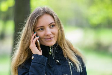 Evet, bir kız sabah bir smartphone ve kahve ile bir parkta yürüyor