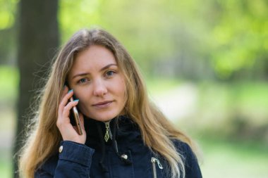 Evet, bir kız sabah bir smartphone ve kahve ile bir parkta yürüyor