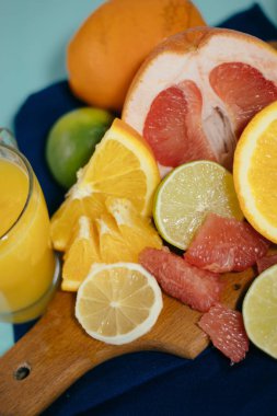 Narenciye, portakal, limon, limon, greyfurt, pomelo vintage yönetim kurulu, limonata ve cam turkuaz bir arka plan üzerine bir bardak suyu