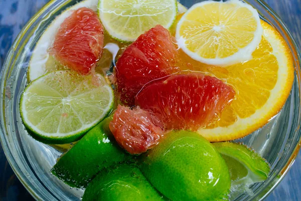 Şeffaf kabarcıkları ile suda narenciye plaka portakal, limon, greyfrut, Pamela limonata — Stok fotoğraf