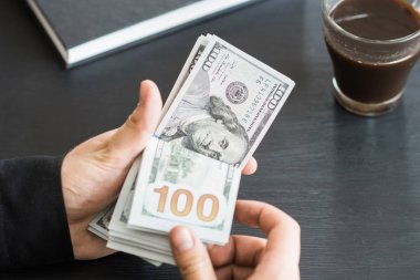 tekrar sayım dolar ver. adam parayı sayar. yeni yüz dolarlık banknot. Yeni Finans teknolojileri ve iş haberleri kavramları. Yatay