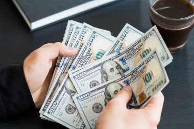 Dolarları elle saymak. Adam parayı sayıyor. yeni yüz dolarlık banknotlar