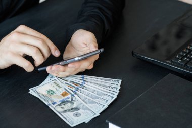 Teknoloji, online bankacılık, para transferi, e-ticaret kavramı. Kullanma smartphone dolarlarına gri duvar arka plan üzerinde uçan iş adamı. Internet kazanç kavramı