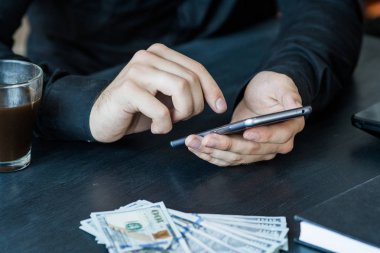 Teknoloji, online bankacılık, para transferi, e-ticaret kavramı. Kullanma smartphone dolarlarına gri duvar arka plan üzerinde uçan iş adamı. Internet kazanç kavramı