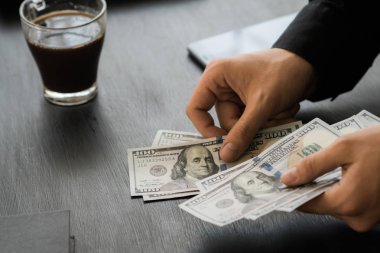 Beyaz genç işadamı para sayar, yüz dolar faturaları bir siyah arka plan yakın plan, Motion blur. İş ve finans kavramları. üstten görünüm 100 $