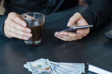 Teknoloji, online bankacılık, para transferi, e-ticaret kavramı. Kullanma smartphone dolarlarına gri duvar arka plan üzerinde uçan iş adamı. Internet kazanç kavramı