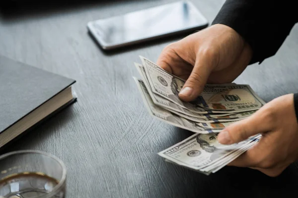 Beyaz genç işadamı para sayar, yüz dolar faturaları bir siyah arka plan yakın plan, Motion blur. İş ve finans kavramları. üstten görünüm 100 $