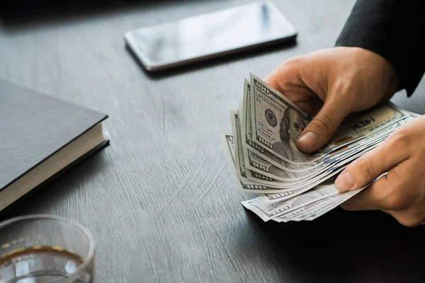 Beyaz genç işadamı para sayar, yüz dolar faturaları bir siyah arka plan yakın plan, Motion blur. İş ve finans kavramları. üstten görünüm 100 $