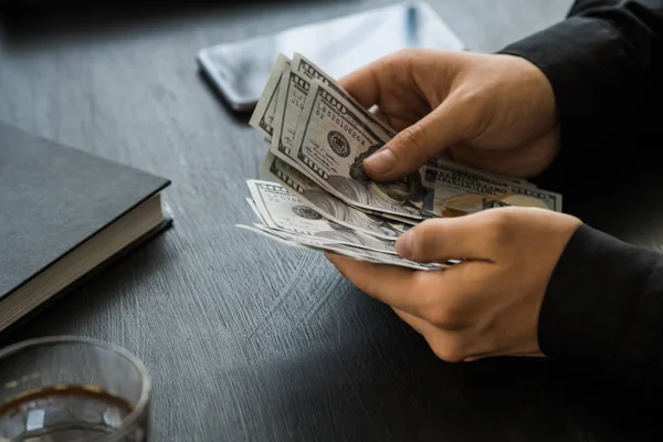 Beyaz genç işadamı para sayar, yüz dolar faturaları bir siyah arka plan yakın plan, Motion blur. İş ve finans kavramları. üstten görünüm 100 $