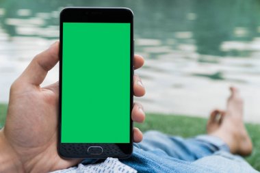chroma anahtar yeşil ekran ile mobil akıllı telefon gren arka planda tutan adamın elini