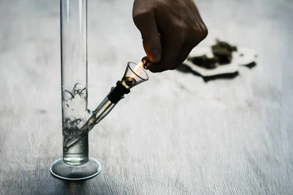 Man smokes using Bong and medical marijuana, cannabis thc flower Sativa and Indica Close up on a black background. lifestyle Concepts the legalization of marijuana in the world and the United States. — Stock Photo, Image