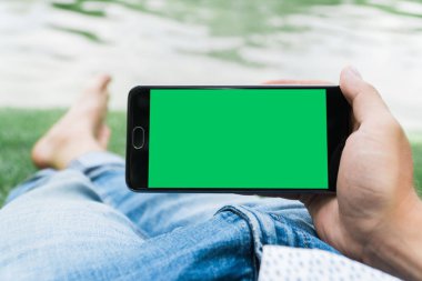 chroma anahtar yeşil ekran ile mobil akıllı telefon gren arka planda tutan adamın yakın çekim el