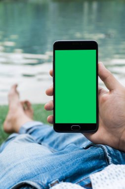 chroma anahtar yeşil ekran ile mobil akıllı telefon gren arka planda tutan adamın yakın çekim el