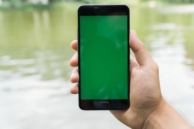 chroma anahtar yeşil ekran ile mobil akıllı telefon gren arka planda tutan adamın yakın çekim el