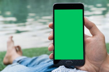 chroma anahtar yeşil ekran ile mobil akıllı telefon gren arka planda tutan adamın yakın çekim el