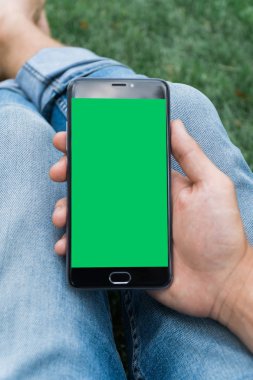 chroma anahtar yeşil ekran ile mobil akıllı telefon gren arka planda tutan adamın yakın çekim el