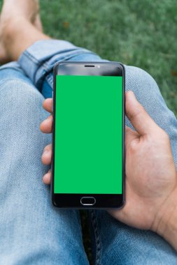 chroma anahtar yeşil ekran ile mobil akıllı telefon gren arka planda tutan adamın yakın çekim el
