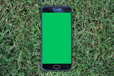 yakın çekim smartphone anahtar chroma ekran için yeşil ekran ile. arka plan smartphone ile yeşil çimen