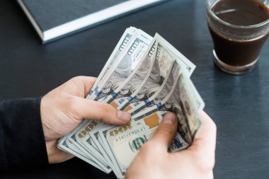 tekrar sayım dolar ver. adam parayı sayar. yeni yüz dolarlık banknot. Yeni Finans teknolojileri ve iş haberleri kavramları. Yatay