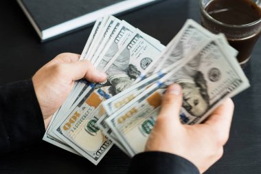 tekrar sayım dolar ver. adam parayı sayar. yeni yüz dolarlık banknot. Yeni Finans teknolojileri ve iş haberleri kavramları. Yatay