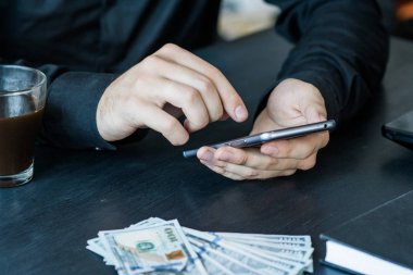 Teknoloji, online bankacılık, para transferi, e-ticaret kavramı. Kullanma smartphone dolarlarına gri duvar arka plan üzerinde uçan iş adamı. Internet kazanç kavramı