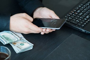 Teknoloji, online bankacılık, para transferi, e-ticaret kavramı. Kullanma smartphone dolarlarına gri duvar arka plan üzerinde uçan iş adamı. Internet kazanç kavramı