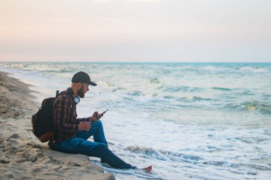 Onun sabah fincan kahve okyanus görünümüne bakarak ile genç turist adam