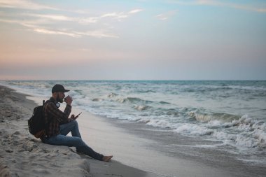 Turist onun sabah fincan kahve okyanus görünümüne bakarak ile genç adam