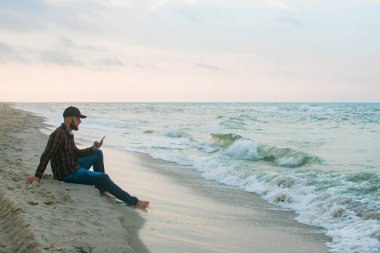 Onun sabah fincan kahve okyanus görünümüne bakarak ile genç Freelancer iş adamı