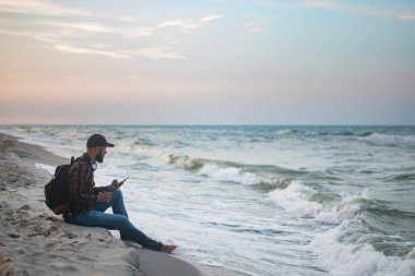 Onun sabah fincan kahve okyanus görünümüne bakarak ile genç turist adam