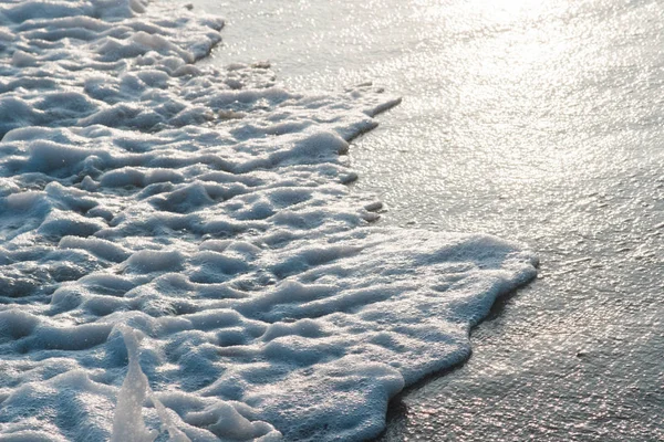 Derin mavi fırtınalı deniz suyu yüzeyi köpük ve dalga desenli, doğal arka plan fotoğrafı.