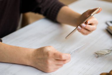 Kredi kartı tutan ve online alışveriş için cep telefonu kullanan bir kadın..